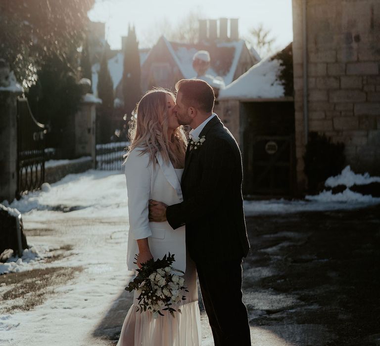 The sun shines down on the bride and groom for their registry office winter wedding in the Cotswolds 