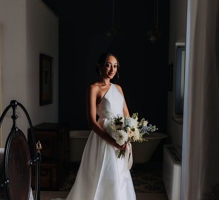 Bride in a one shoulder wedding dress on the morning of her wedding 