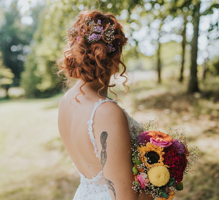 tousled bridal up do with fresh flowers in her hair 