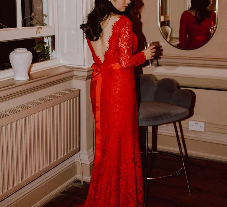 Bride in v-back red lace wedding dress with long sleeves and red and gold hair accessories at The Orangery Maidstone wedding venue 