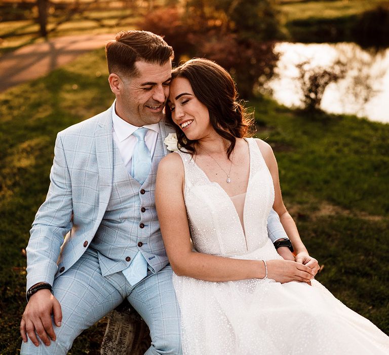 Golden house bride and groom portraits with groom in a light blue check suit and bride in a sparkly wedding dress