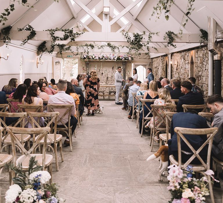 Pink and blue pastel wedding flowers decorate the aisle and altar at Wyresdale Park in Lancashire 