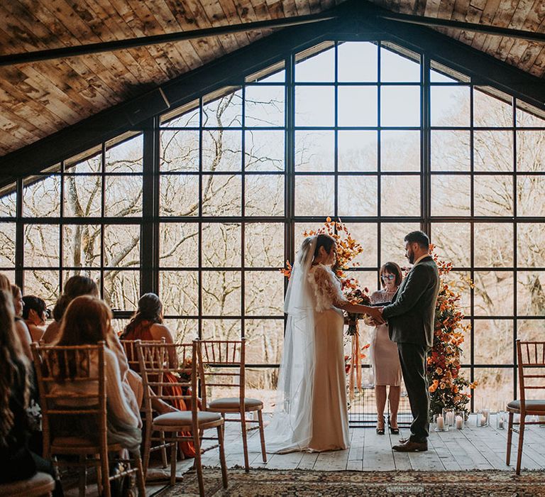 Hidden River Barn wedding venue in Carlisle with the bride and groom facing together at their humanist and bespoke wedding ceremony 