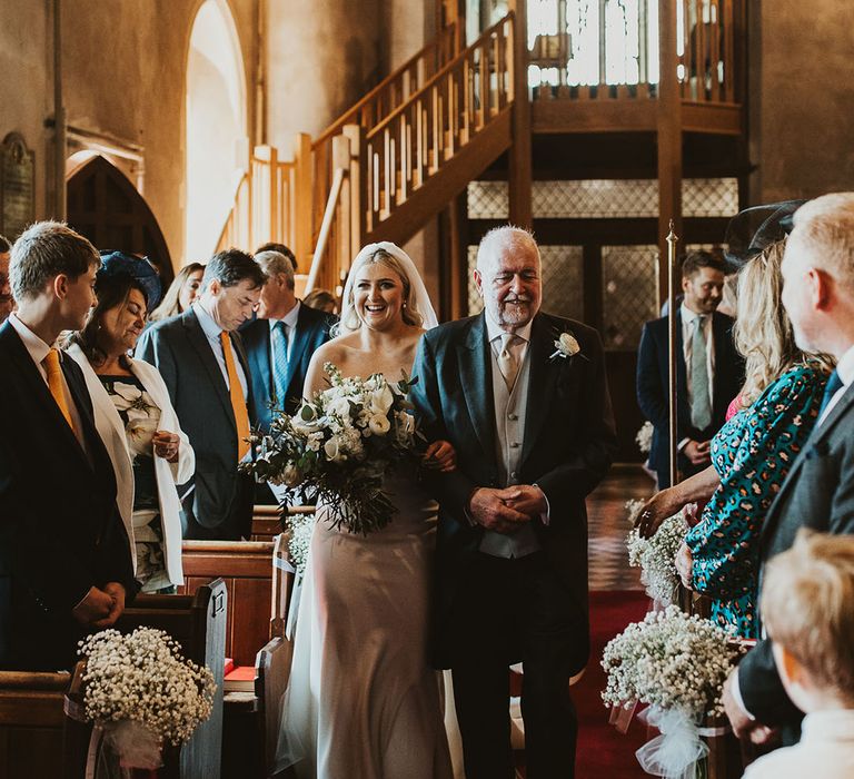 Father of the bride in black and grey morning suit walking down the aisle with the bride in an Eva Lendel wedding dress 