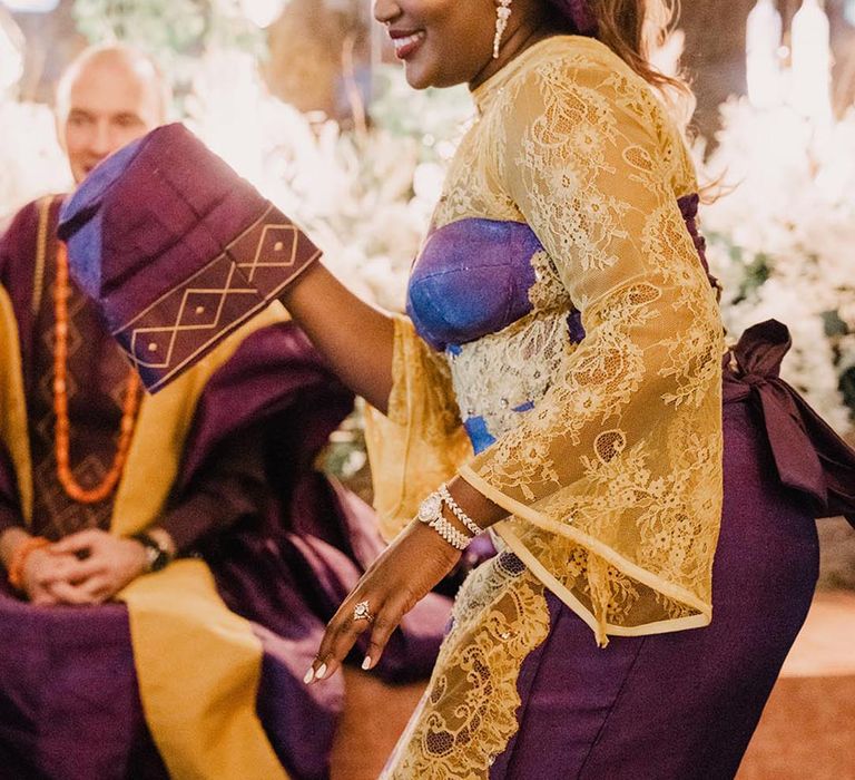 Bride and groom in purple and gold traditional Yoruba wedding attire 