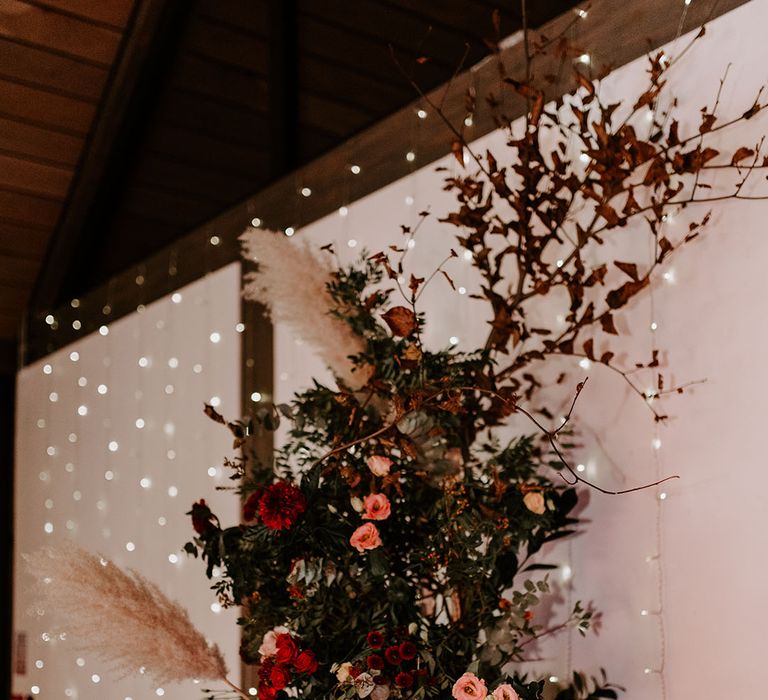 Wedding flower column decoration with red roses, autumn leaves, pampas grass and more 