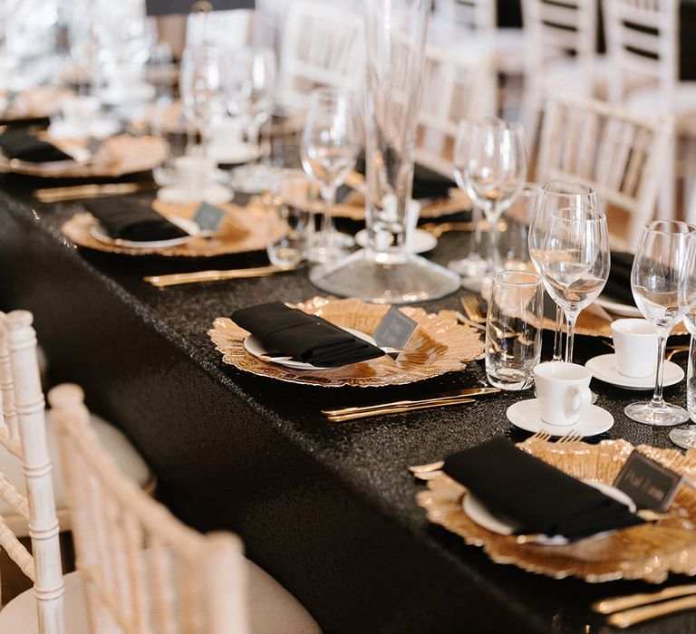 Gold charger plates with black napkins and place names 