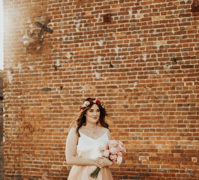 Bride with flower crown and tulle blush skirt on wedding day