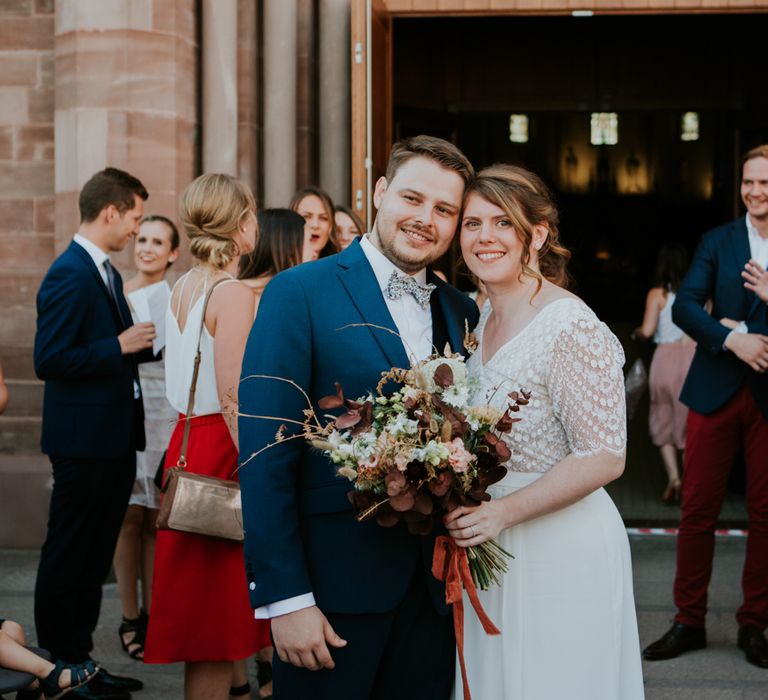 Bride and groom posing outside the church 