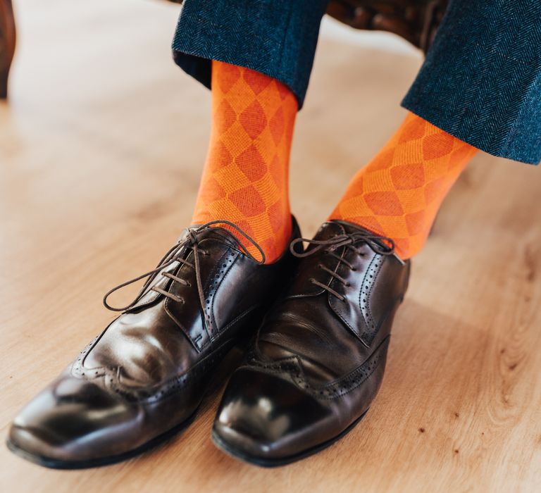 Groom in bright orange checkered socks and brown shoes