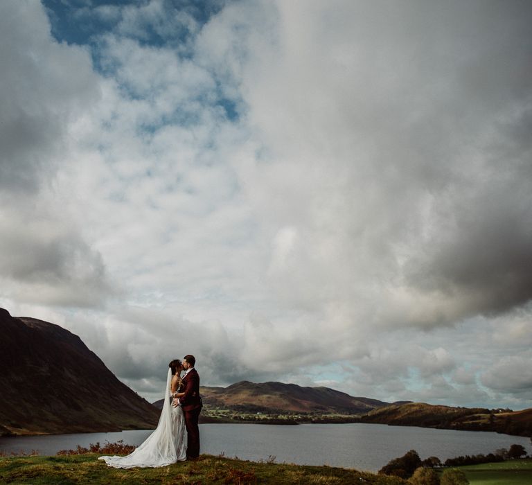 Bride and Groom kissing in front of Lake District scenery