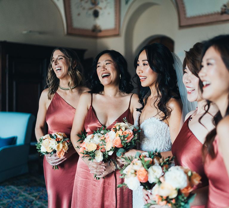 Bridesmaids in coral satin dresses 