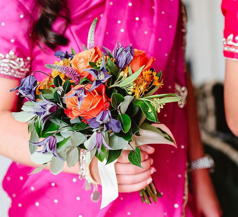 Fuchsia pink bridesmaid dress with brightly coloured bouquet