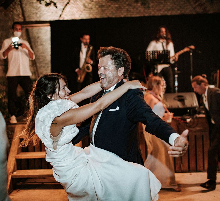 Father of the bride and his daughter in a ruffle sleeve wedding dress dancing at the Italian destination wedding 