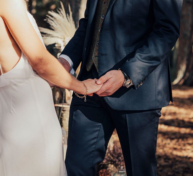 Bride & groom hold hands during wedding ceremony