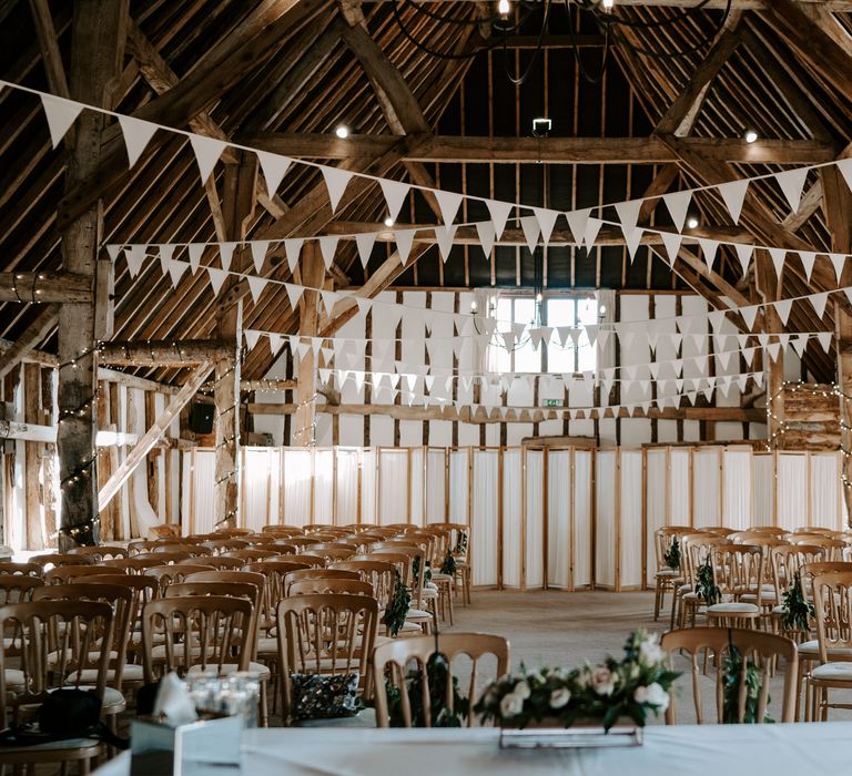 Ceremony room at Clock Barn wedding venue with gold chairs, bunting and fairy lights decor 