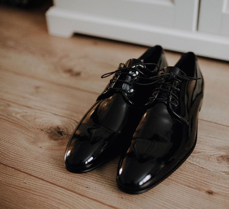 Black grooms shoes on wooden floor