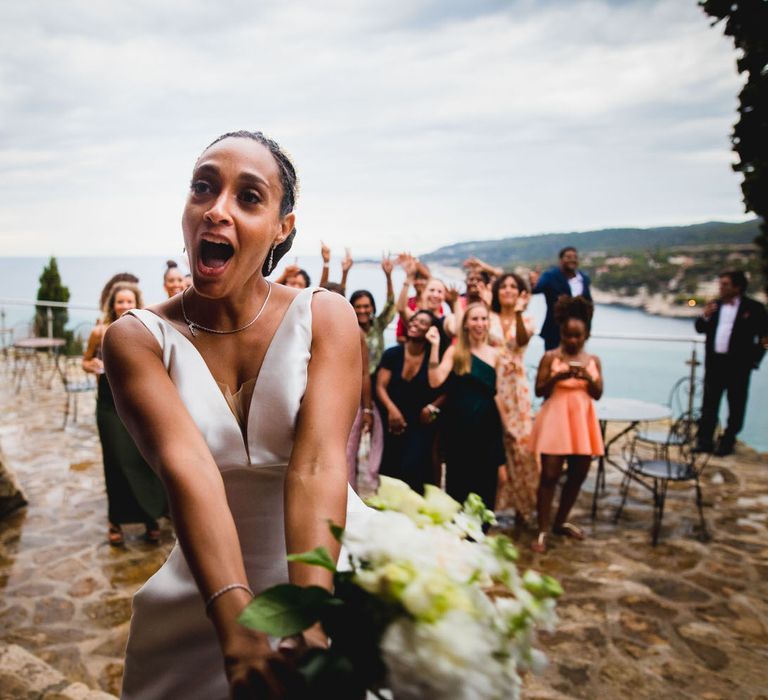 The bride getting ready to throw her bouquet into the crowd at her Chateau wedding in South of France