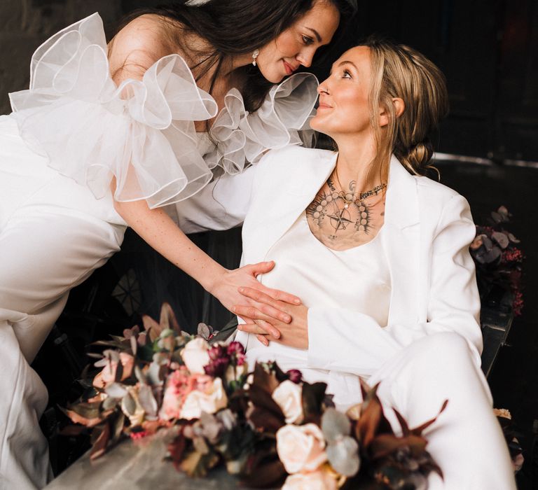 Lesbian wedding with portrait of the brides looking intently at each other 