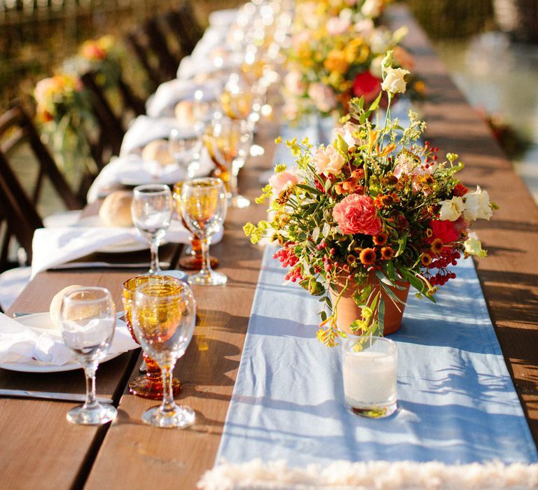 Simple and elegant wedding banquet table with linen table runner and terracotta flower pots