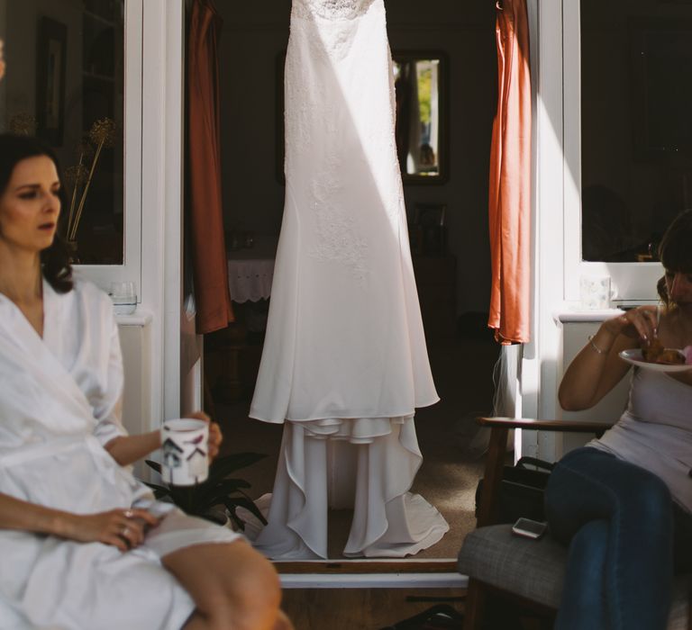 Brides dress hangs up on the morning of her wedding