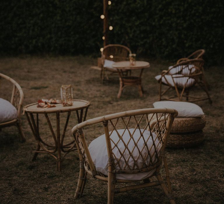 outdoor seating area with festoon lights and wicker chairs 