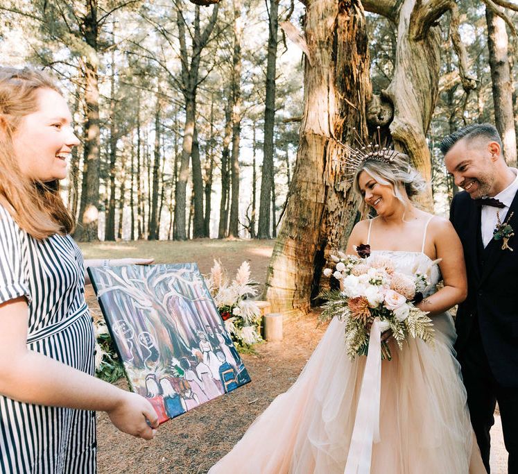 Bride and groom admire live painting artwork