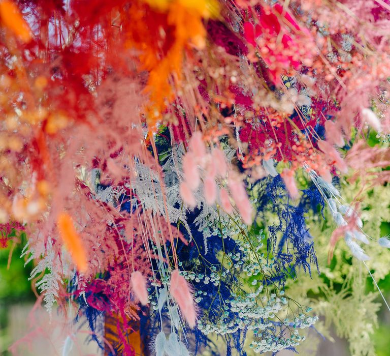 Rainbow coloured pampas grass as wedding archway