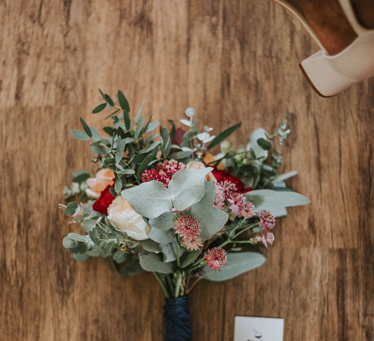 Red white and green wedding bouquet with eucalyptus