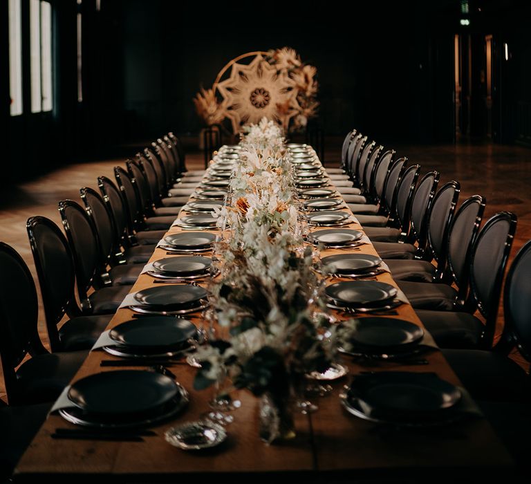 Dark room of the Gare Saint-Lazare with decorated reception table featuring grey slate plates and bouquets