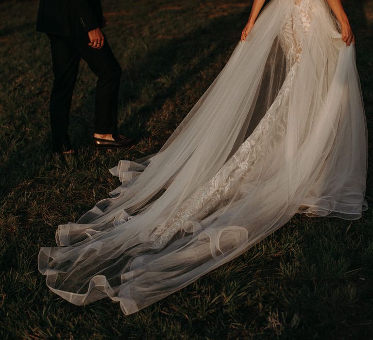 Brides long tulle wedding dress train with embroidered lace underskirt