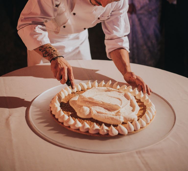 Chef creates wedding cake for bride & groom as wedding party watch