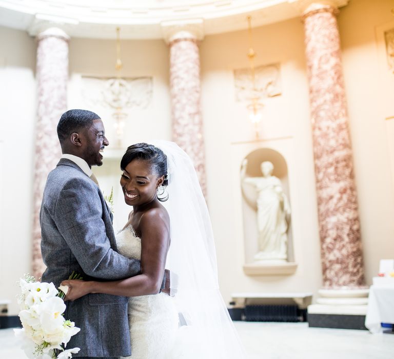 Black bride & groom embrace in stately room at the Stowe House