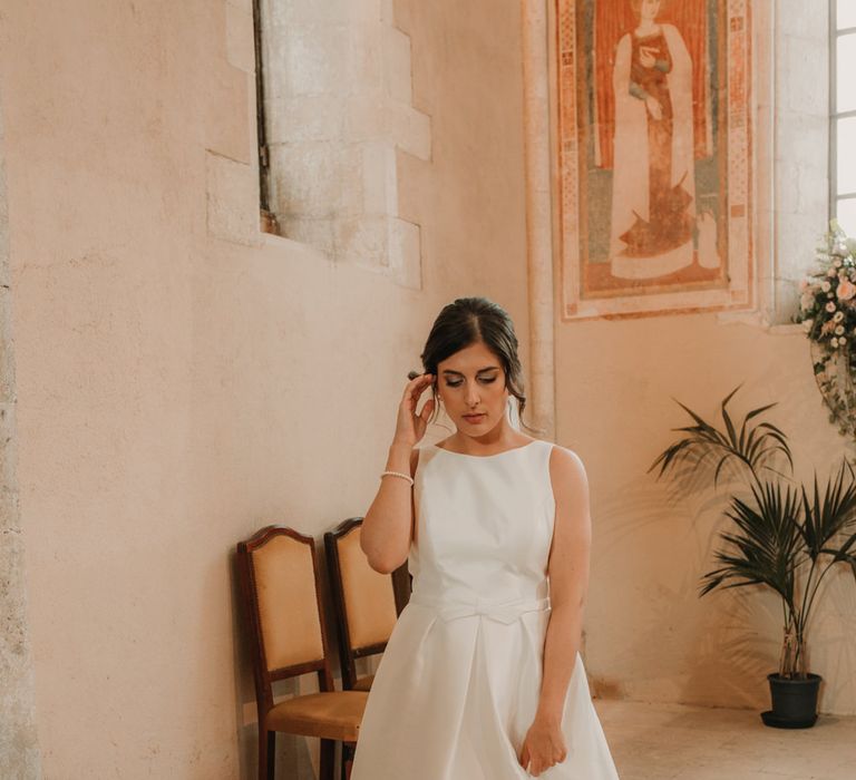 Bride in a high neck, sleeveless Rosa Clara wedding dress with bow waist detail. 