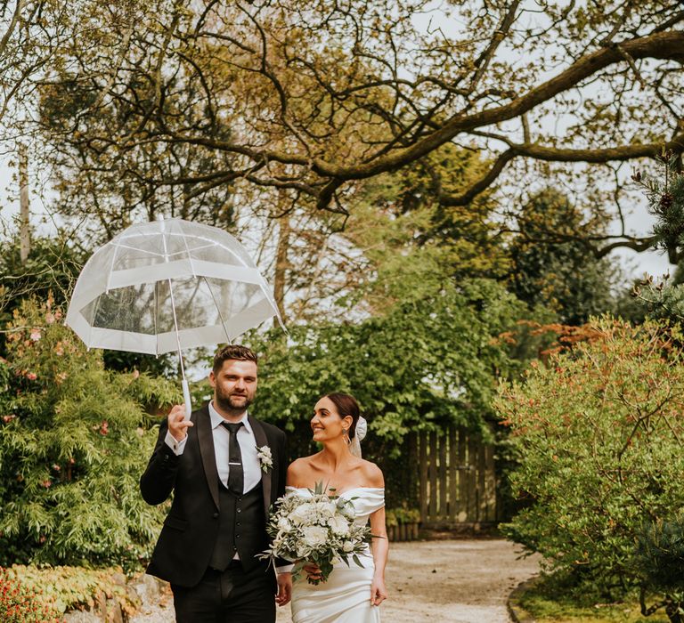 Groom carries umbrella and intimate Irish wedding