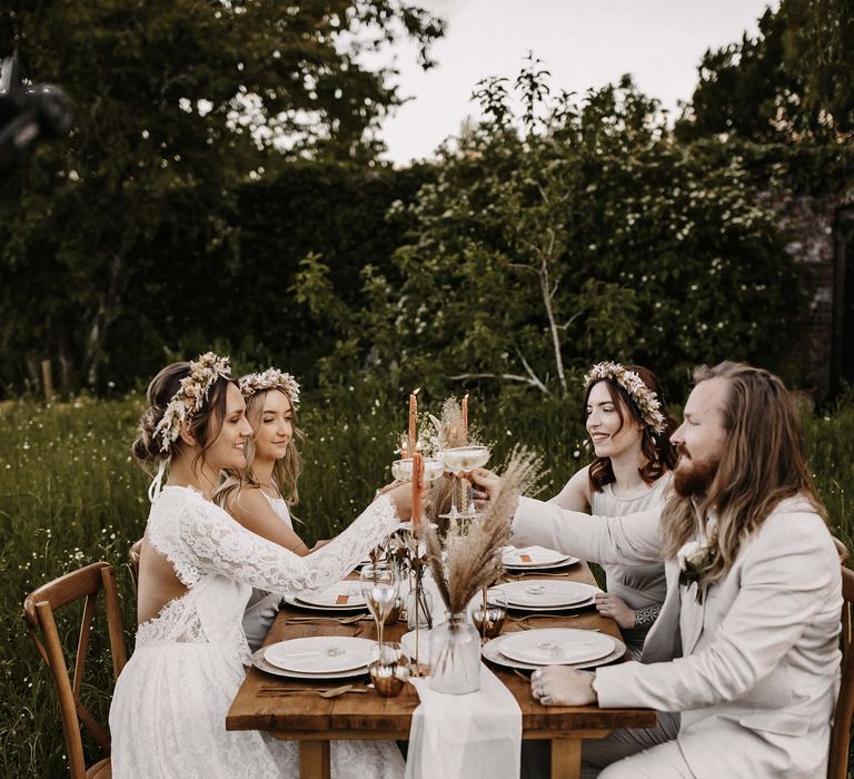 Intimate outdoor wedding reception at The Secret Garden, Kent with bride in a lace wedding dress and flower crown