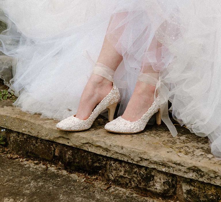 Bride in a tulle wedding dress wearing Di Hassall embellished wedding shoes with ankle strap 