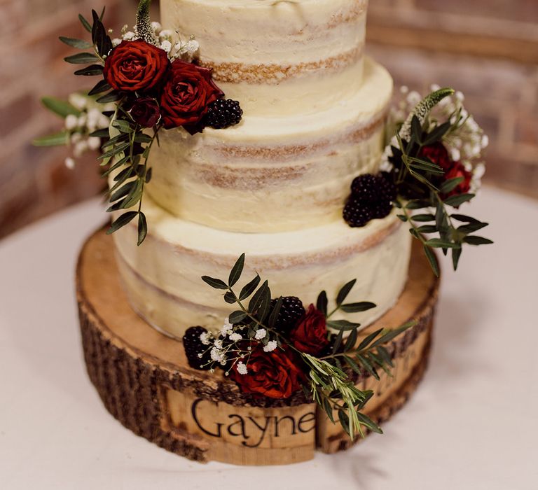 Naked rustic wedding cake complete with white frosting and floral decor | Joshua Gooding Photography