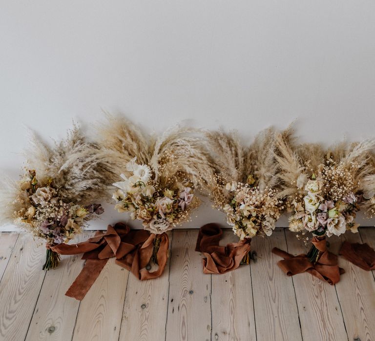 Neutral bouquets with pampas grass tied with rust coloured satin ribbon