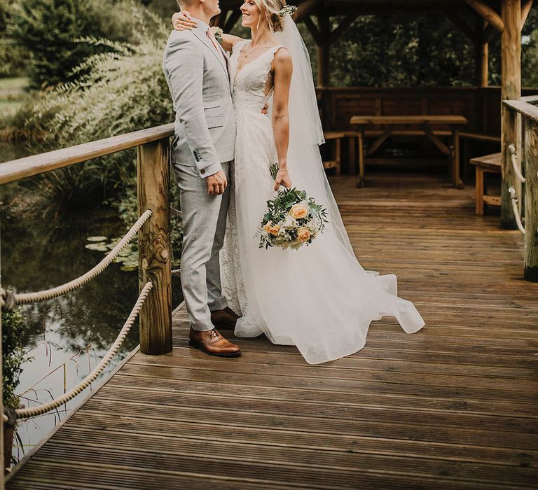 Bride clutches bouquet as she shares a moment with new husband at Chycara