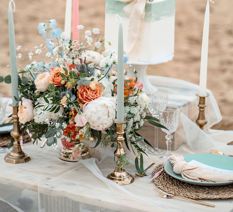 Pastel wedding table decor with floral centrepiece, taper candles and ombre buttercream wedding cake 