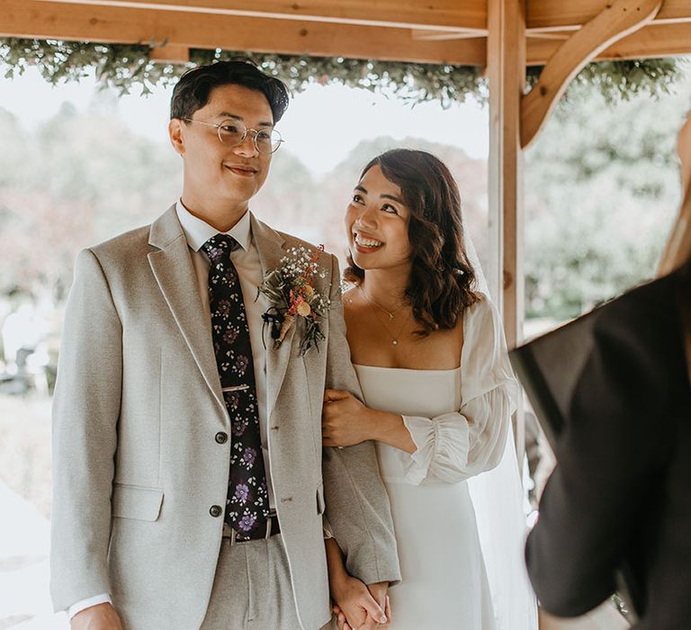 Bride & groom during wedding ceremony outdoors 