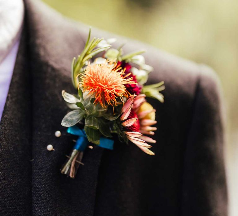 Brightly coloured buttonhole matching bouquet for groom