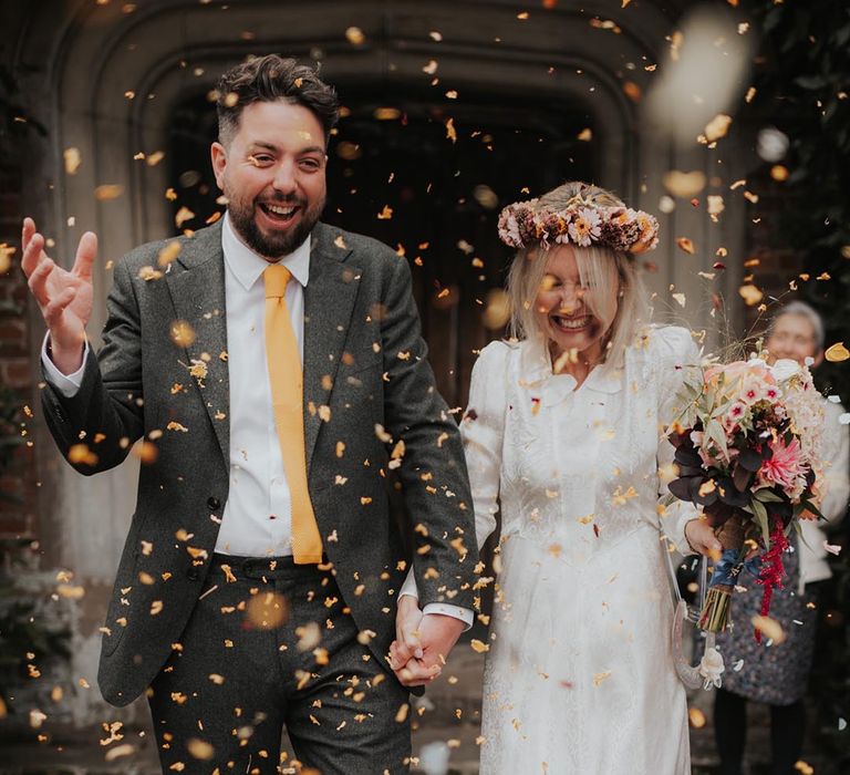 Confetti moment for bride and groom at country house wedding