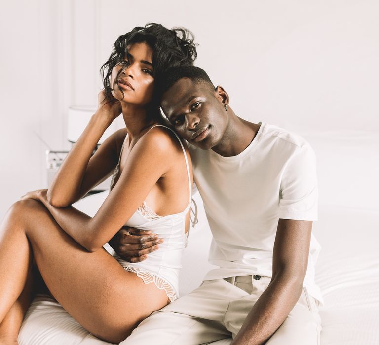 Black groom in a white cotton t-shirt embracing his South Asian bride in a getting ready robe on the wedding morning of their Paris elopement 