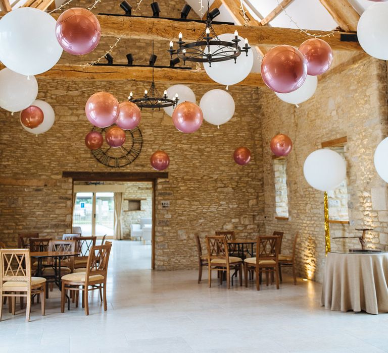 Giant white and pink hellium balloons decorating barn wedding venue 