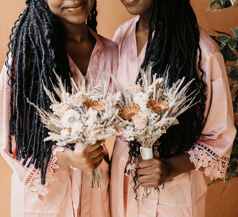 Bridesmaids hold dried floral rustic bouquet