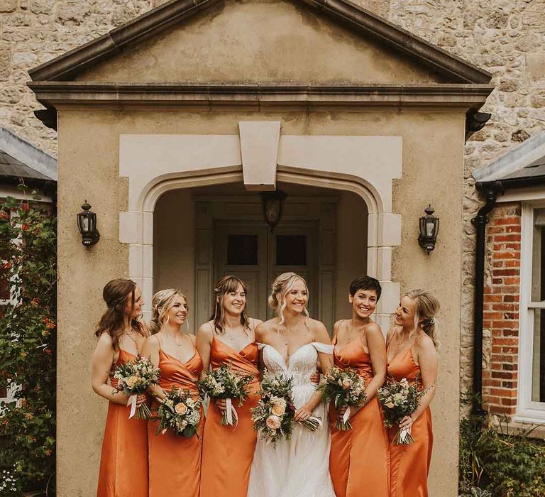 bridesmaids wearing orange satin bridesmaid dresses 