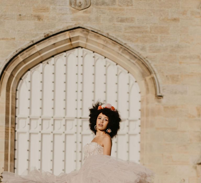 Black bride in a pink tulle skirt twirling at Chiddingstone Castle wedding venue in Kent 