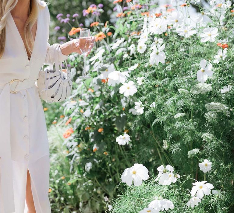 Bon Bride dress with plunging neckline, buttons, long sleeves, belt and front slit with matching white bag 